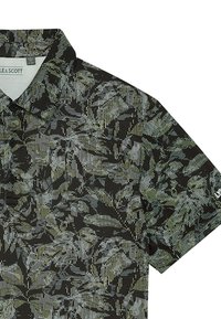 Svart och grå pikétröja med abstrakt bladmönster, korta ärmar och tre svarta knappar på fronten.