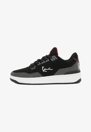Czarno-szare sneakersy z teksturowaną cholewką, sznurowaniem, białą podeszwą i detalem z logo. Czerwone akcenty znajdują się na języku i pięcie.