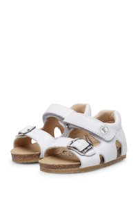 Sandalias de cuero blanco con lados abiertos, dos correas ajustables con hebillas plateadas, plantilla texturizada y suela ligera de color marrón.