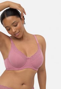 Sostenedor rosa con textura acanalada y trim de encaje, con tirantes ajustables y forma redondeada. Textura suave, diseñado para comodidad y soporte.