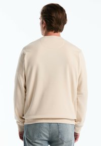 Beige crewneck sweatshirt met een gladde textuur, ribgebreide manchetten en onderrand, met een effen achterkant en een zachte, relaxte pasvorm.