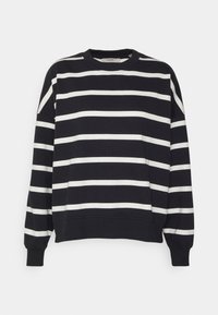 Sudadera a rayas en blanco y negro con cuello redondo, hombros caídos y puños ribeteados en las mangas y el dobladillo. Textura de tela suave.