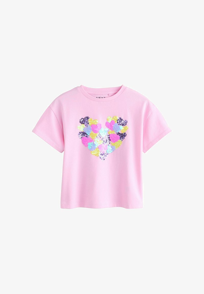 Maglietta in cotone rosa con un design a cuore realizzato con paillettes multicolori in giallo, viola, blu e verde. Maniche corte e girocollo.