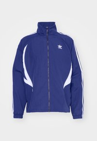 Navy blue track jacket with a high collar, front zipper, white side stripes, and an Adidas logo on the chest. Soft fabric with elastic cuffs.