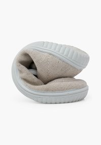 Helle graue Stoffschuhe mit strukturiertem Obermaterial und einer weißen Gummisohle, nach innen gefaltet, um das Innenfutter und die weiche Konstruktion zu zeigen.