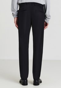 Pantaloni formali neri con taglio dritto, dotati di due tasche posteriori e passanti per cintura. Il tessuto sembra liscio con una leggera lucentezza.