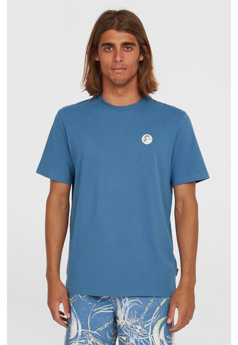 Blue short-sleeve t-shirt made of cotton, featuring a round neck and a small logo patch on the chest. Smooth texture, regular fit.