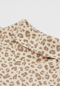 Leopardenmusterstoff in Beige mit braunen Flecken, mit einer weichen Textur und einem umgeschlagenen Kragen-Design.