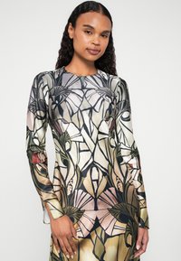 Φόρεμα με μακρύ μανίκι φτιαγμένο από λείο ύφασμα, διακοσμημένο με λουλουδάτο σχέδιο σε κρέμ, μαύρο και πράσινο, με ανοιγμένα μανίκια στους καρπούς και εφαρμοστή σιλουέτα.