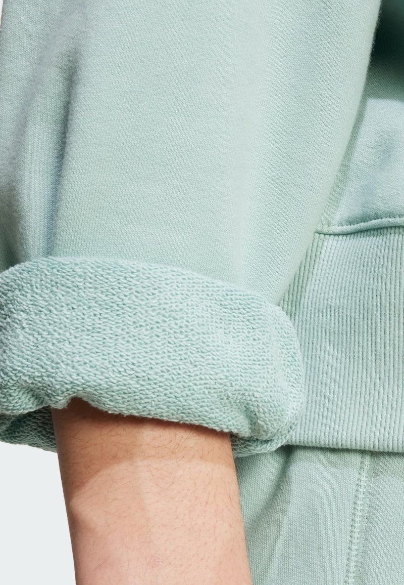 Jasnozielona bluza z teksturowanym mankietem z pętlicą. Rękaw ma miękkie wykończenie oraz ściągacz przy otworze rękawa.