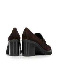 Chaussures à talons hauts en daim marron avec un talon noir épais et une pointe ronde, présentant des détails de couture et une semelle texturée.