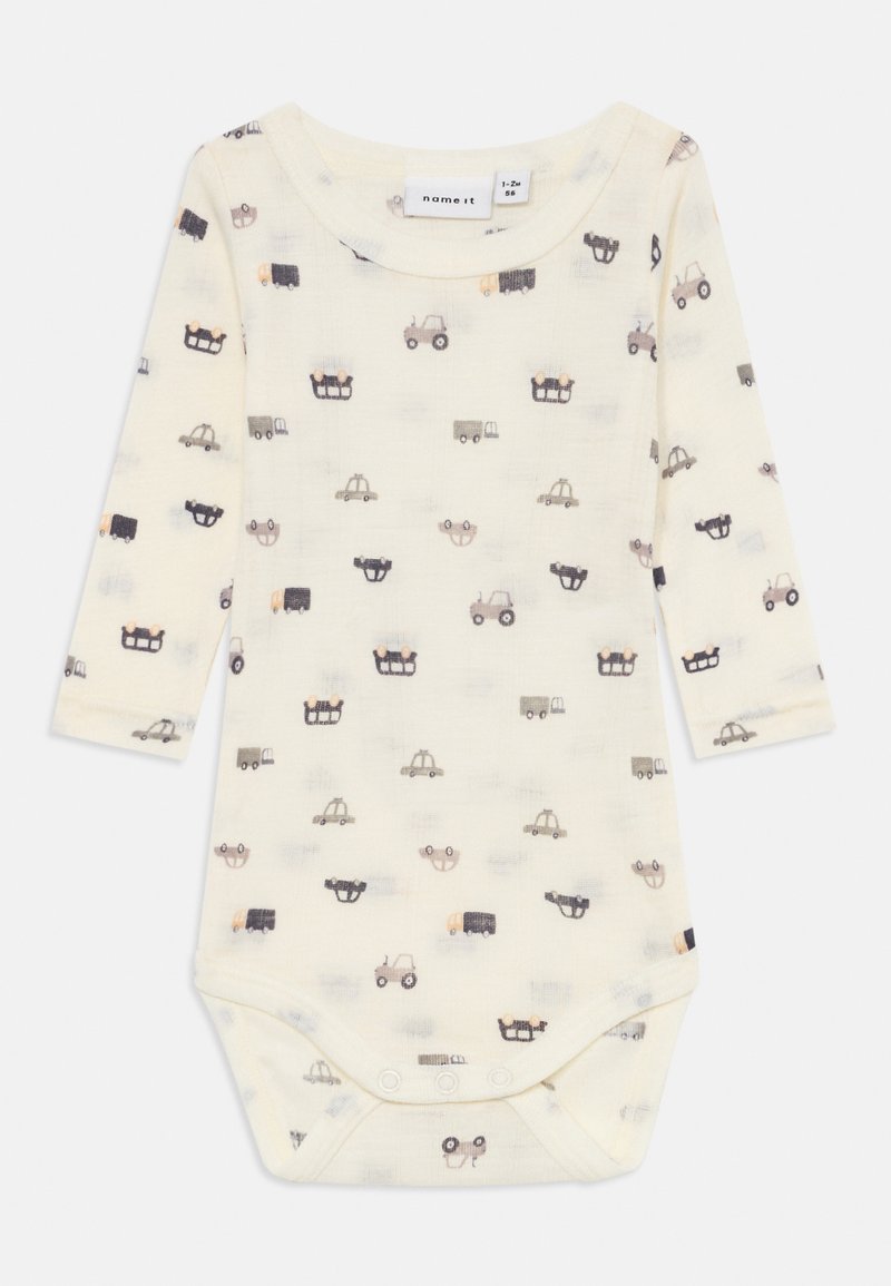 Bodysuit de manga longa em crème claro com um padrão repetido de vários veículos em estilo de cartoon em cores suaves. Com botões na parte inferior para fácil vestimenta.