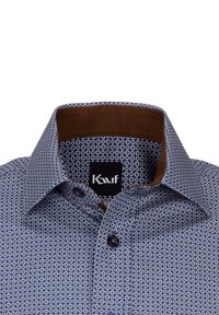 Camicia a maniche corte con tessuto a fantasia blu caratterizzato da piccoli cerchi bianchi, colletto interno marrone e bottoni scuri. Etichetta del marchio visibile.
