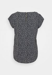 Blouse noire à manches courtes avec petit motif floral blanc et bleu et une fermeture éclair dans le haut du dos.