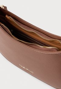 Bolsa de ombro em couro castanho com vários compartimentos com zíper e ferragens em tom dourado, apresentando um acabamento texturizado e logótipo de marca.