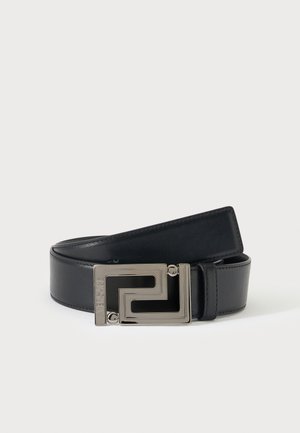 Ceinture en cuir noir avec une boucle géométrique argentée comportant un nom de marque embossé sur un fond clair.