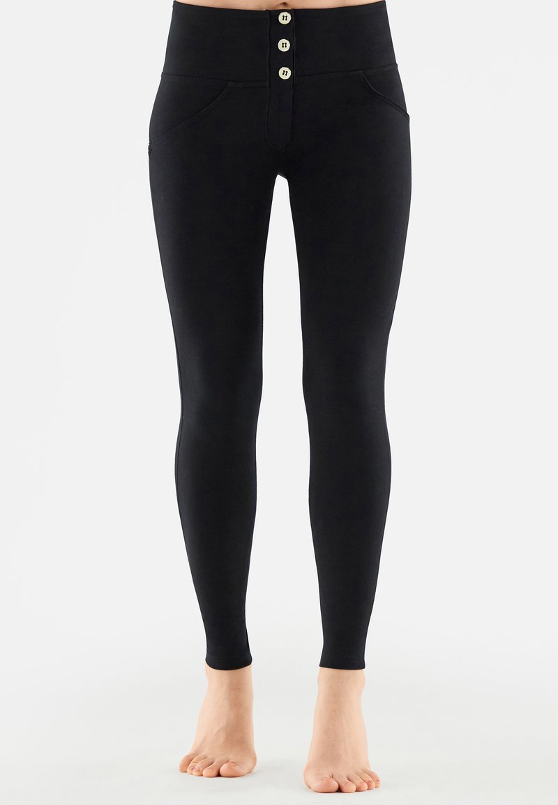 Leggings negros de cintura alta fabricados con tejido elástico, que cuentan con un cierre de botones en la parte delantera, dos bolsillos laterales y una textura suave.