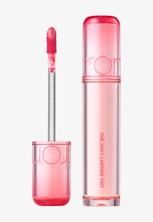 Vaaleanpunertava huulikiilto, applikaattori nostettu pois, jolloin näkyvissä on karvainen applikaattorikärki, joka on peitetty kiiltävällä vaaleanpunaisella sävyllä.