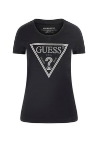 Sort bomulds T-shirt med kortærmer, der har et trekantet metallisk logo-design med teksten "GUESS" og "WASHED JEANS" i sølv accenter.