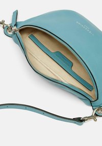 Borsa in pelle blu con una texture liscia, dotata di chiusura con zip, foderatura interna beige e tracolla rimovibile. Inclusa una tasca per carte interna.
