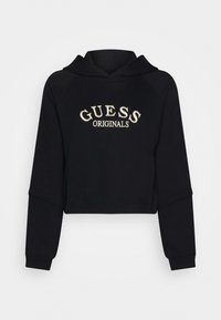 Svart kort hoodie i mjukt material, med huva och raglanärmar. "GUESS ORIGINALS" broderat i krämfärgat på framsidan.