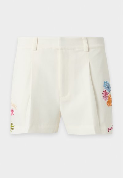 Short blanc sur mesure avec passants de ceinture et broderie florale colorée de chaque côté près de l’ourlet.