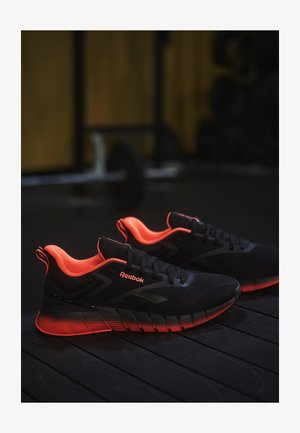 Sorte sportsko med orange detaljer, struktureret mesh-overdel, med mærke-logo, polstret krave og en dæmpet sål.