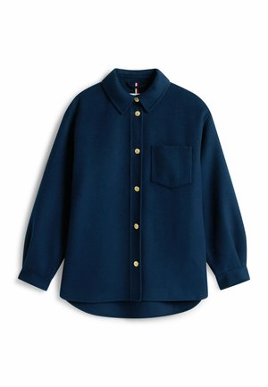 Navyblaue Wollbluse mit Kragen, langen Ärmeln, goldenen Knöpfen und einer Brusttasche. Das Design zeichnet sich durch einen abgerundeten Saum und eine weiche Textur aus.
