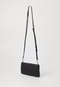 Black woven handbag made of leather, featuring a rectangular shape, slim adjustable strap, and a textured, padded surface.