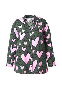 Groene knoopshirt met een groot roze hartpatroon en zwarte accenten. Lange mouwen en een v-halsontwerp maken de look compleet.