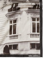 Hedvábny šál s monochromatickým architektonickým dizajnom, so zdôraznenými oknami a balkónmi, obšitý čiernou farbou, s označením "KARL LAGERFELD."