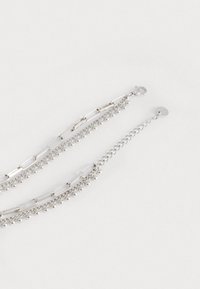 Collana in argento con maglie allungate, piccole perline decorative e chiusura a gancio. La finitura testurizzata aumenta l'interesse visivo.