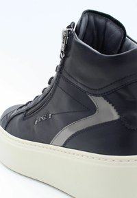 Baskets montantes en cuir noir avec accents gris, dotées d'une fermeture éclair sur le côté, d'un col rembourré et d'une épaisse semelle blanche. Finition texturée sur le matériau.