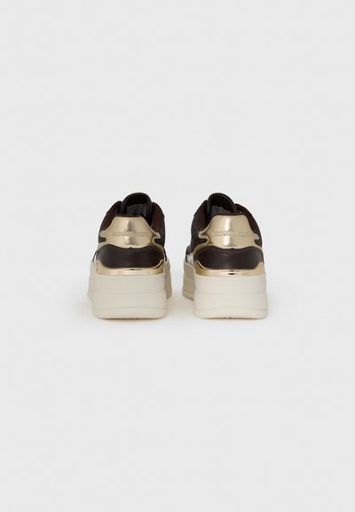 Bruna sneakers med ett texturerat tygöverdrag, metalliska guldaccenter på hälen och en rejäl vit gummisula.