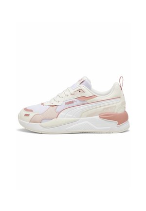 Baskets basses blanches et rose pâle Puma avec dessus en mesh et synthétique, fermeture à lacets, semelle rembourrée et bande latérale brandée.