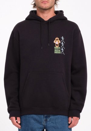 Man wearing black hoodie with yellow and white design of figures and text "The Basis of Molecular Inheritance" on chest.