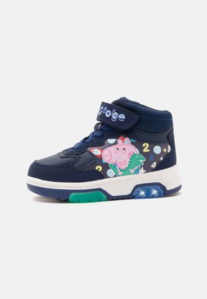 Marineblå børnesneaker med velcrobånd, tegneseriefigur og talprint, grøn såldetalje og to blinkende hvide lys på sålens side.