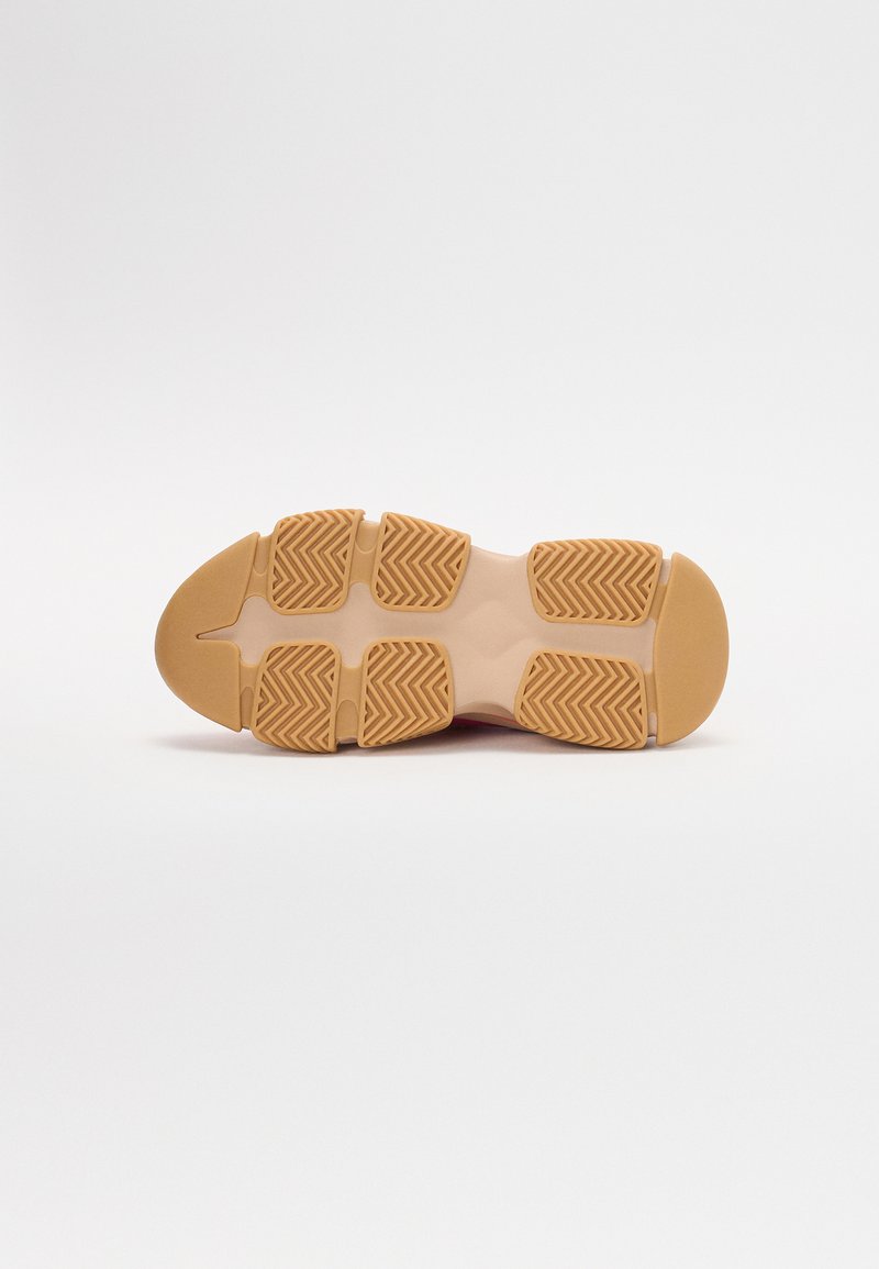 Schoenzool in een lichte beige kleur, met gestructureerde grippatronen en een afgeronde neus. Ontworpen voor grip en stabiliteit.