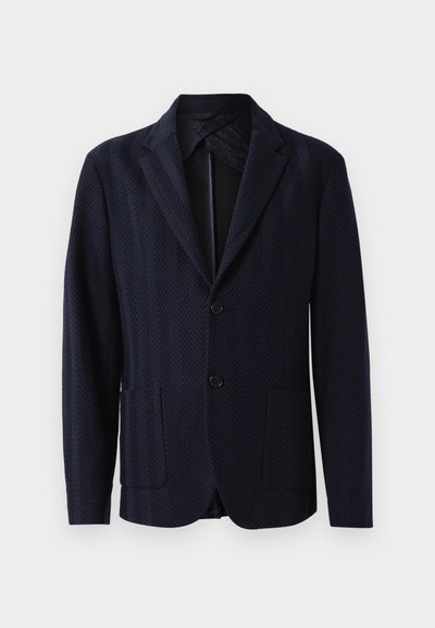 Tumesinine bleiser, millel on herringbone muster, kaks eesmist taskut, ühe nupu kinnitamine ja lõikeklapid, valmistatud tekstureeritud kangast.