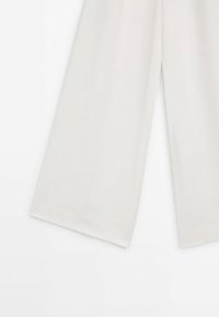 Pantalon blanc à jambes larges présenté de la taille vers le bas sur un fond blanc uni.