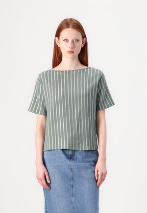 Green striped short-sleeve top with a boat neckline; lightweight fabric; paired with a denim skirt. Simple, boxy design with vertical stripes.