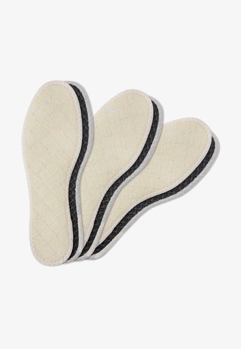 Tre solette per scarpe con un rivestimento superiore in tessuto trapuntato color crema e un fondo in gomma nera testurizzata, bordate con una rifinitura in tessuto grigio.