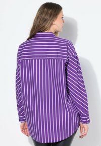 Camicia a maniche lunghe viola con strisce verticali bianche, dotata di polsini abbottonati e orlo curvo, realizzata in un tessuto morbido.