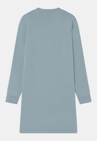 Långärmad, knälång, ljusblå klänning med rundad halsringning och åtsittande ärmslut, visad bakifrån mot en vit bakgrund.