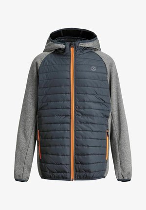 Polstret grå og mørkeblå jakke med hætte, lynlås og kontrasterende ærmer; parret med mørke jeans og hvide sneakers.