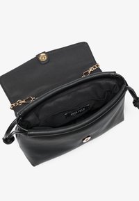 Borsa a tracolla nera in pelle con chiusura a pattina, hardware dorato e un ampio interno foderato in tessuto. Etichetta del marchio visibile all'interno.