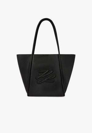 Svart lærveske med teksturert overflate, lange håndtak og forhøyet sydd logo midt foran.