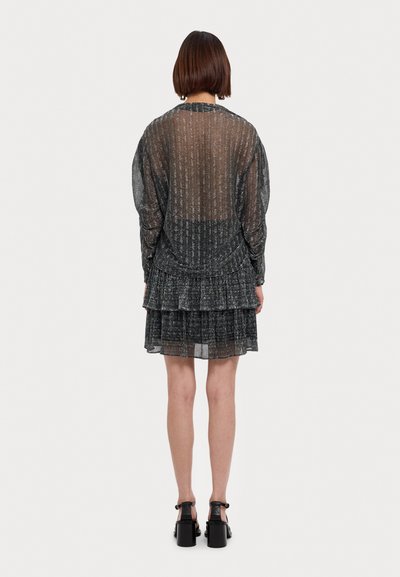 Robe noire transparente avec un design texturé, manches longues, ourlet à volants en niveaux et taille cintrée. Comprend une ouverture en forme de clé à l'arrière.