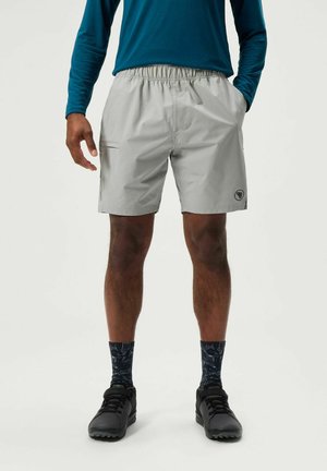Light gray shorts with an elastic waistband, side pocket, and logo detail. Worn with black shoes and patterned navy socks.
