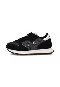 Scarpe da ginnastica nere con pannelli in rete strutturata e suede, dotate di una cinturino con chiusura a strappo e dettagli bianchi sul tallone e sul logo.